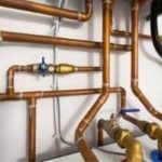 Copper pipework system with brass valves, showcasing plumbing infrastructure solutions by Lodder Brothers Limited.