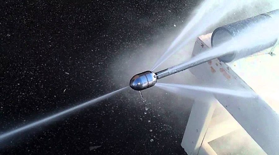 Hydro jetting nozzle spraying high-pressure water, demonstrating effective drain cleaning technology for clearing clogs and debris.