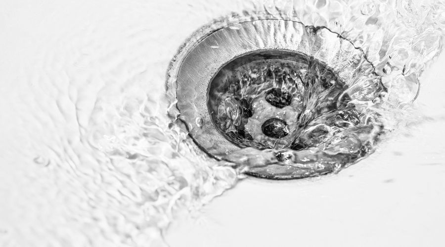 Drain with water flowing, illustrating effective hydro jet drain cleaning for clearing clogs and improving plumbing systems.