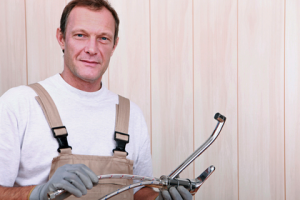 Plumber holding plumbing tools, emphasizing expertise in residential plumbing services and repairs.