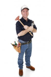 Plumber holding a plunger and wrench, wearing a tool belt with various plumbing tools, representing professional plumbing services for sump pump installation and repair.
